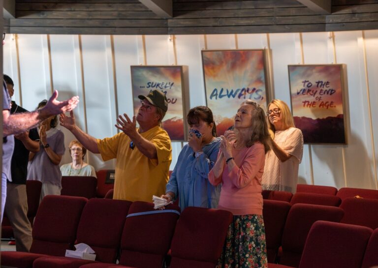 The church stands and worships with joy