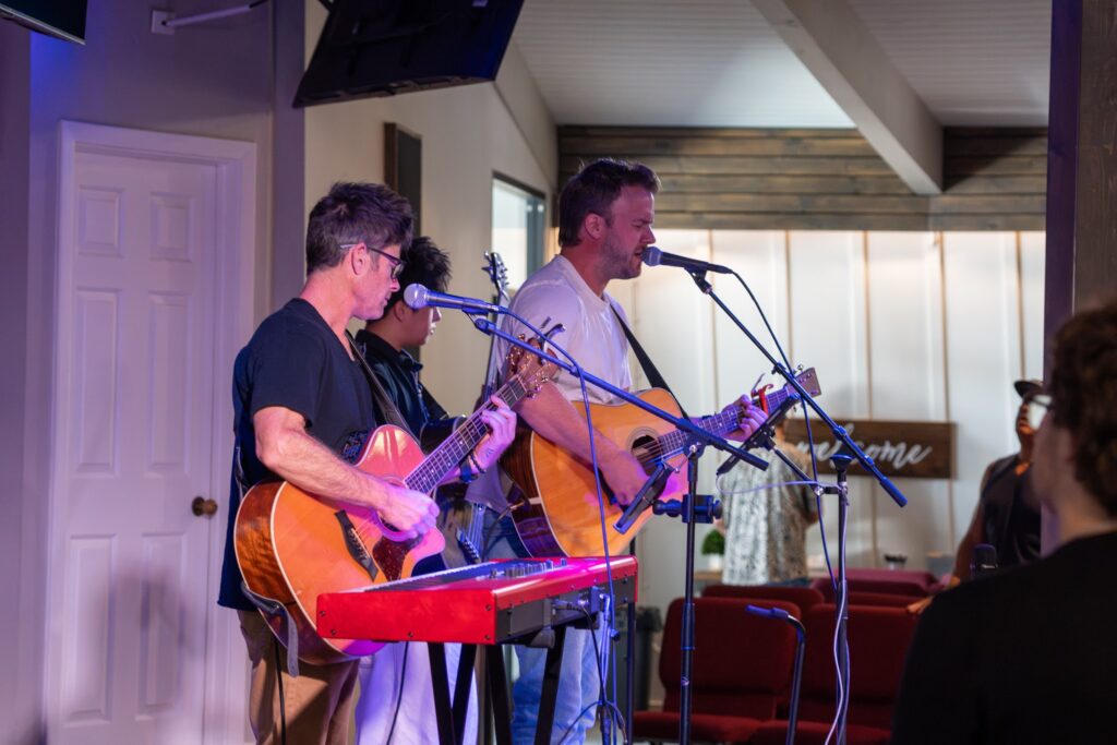 Musicians on guitar and keyboard lead worship